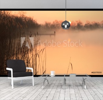 Picture of Foggy and yellow sunrise at a jetty in a lake